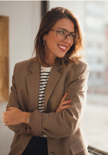 Laura Martin sentada en un espacio contemporáneo de madera y piedra